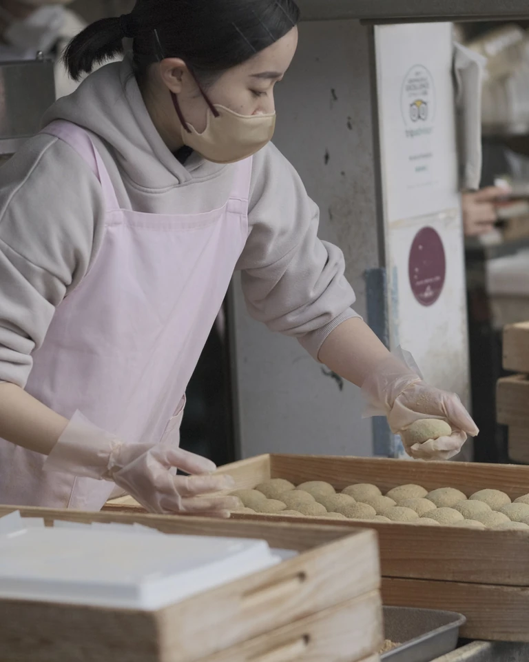 A bakery worker arranging baked goods